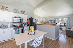 A kitchen with white cabinets, a microwave, a stove, and a refrigerator. - Relaxing Cabin- Hot Tub- Lake View-Fire Pit-Hiking- Walk to Restaurants, Shops (Big Bear Lake)
