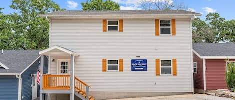 A two-story building with a porch, a flag, and a sign indicating a dock holiday.