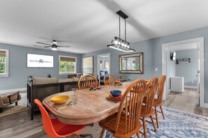 A dining area with a wooden table, chairs, and a ceiling fan. - Steps to Port of Kimberling & Table Rock Lake_Free Attraction Tickets (Kimberling City)