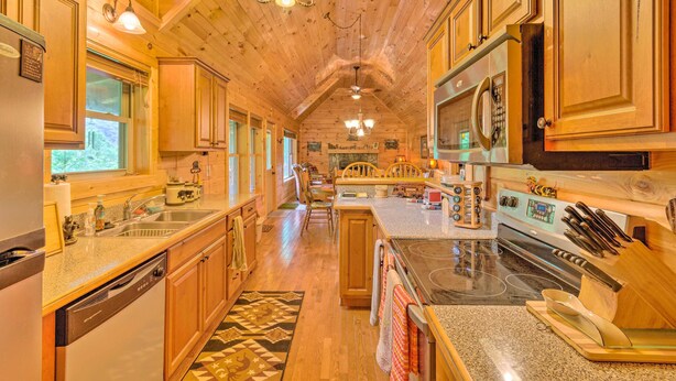A spacious kitchen with wooden cabinets, a granite countertop, a built-in oven, and a dishwasher.