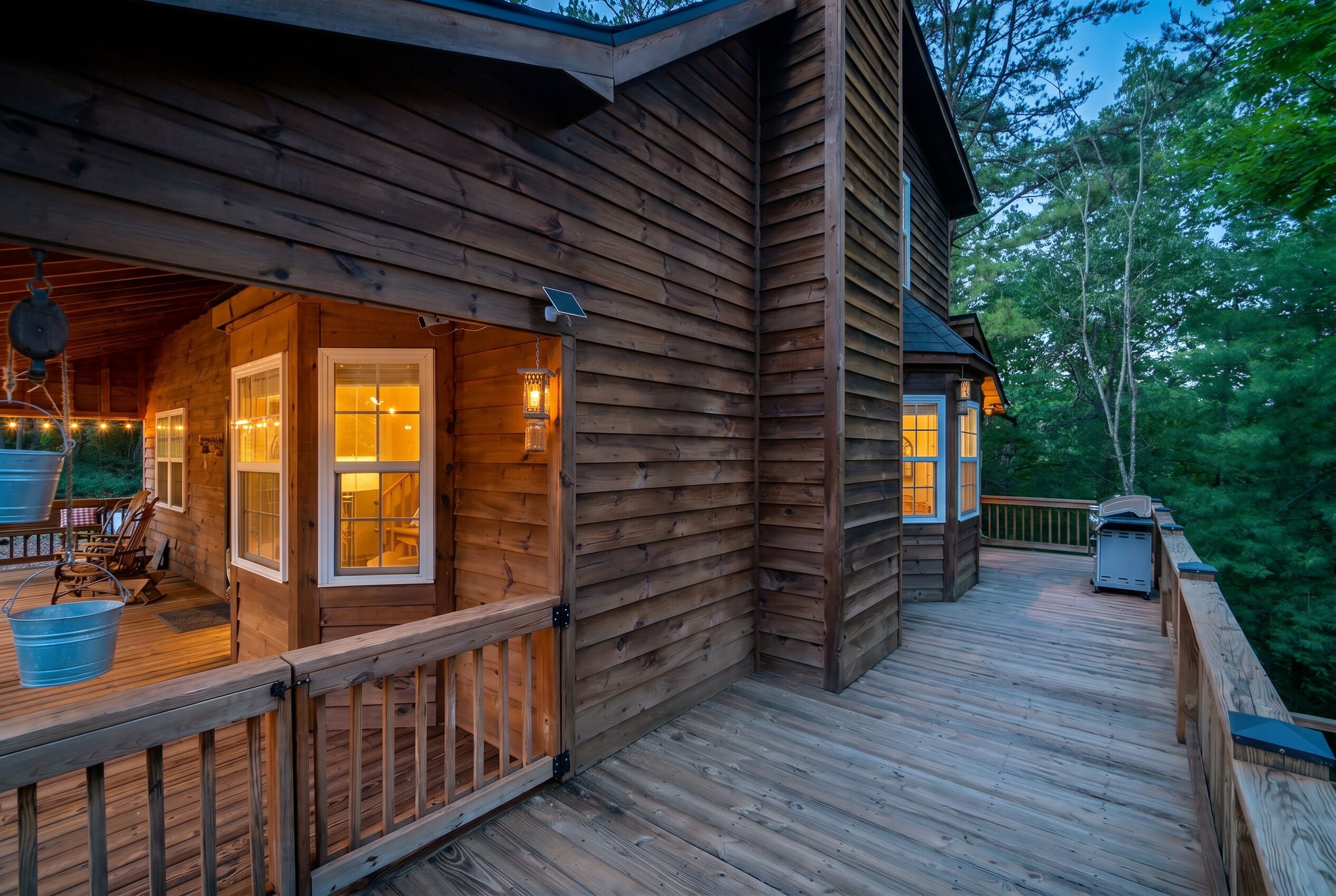 Une cabane en bois dotée d’une terrasse, d’un porche couvert et offrant une vue sur la forêt environnante.