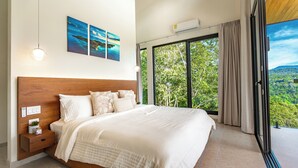 Un dormitorio con una cama grande, una mesita de noche, aire acondicionado instalado en la pared y una ventana con cortinas.