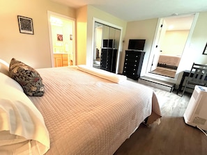 A bedroom with a bed, a dresser, a mirror, and a television. - Private Indoor Heated Pool inside Spacious 4-bedroom house in serene Escanaba (Escanaba)