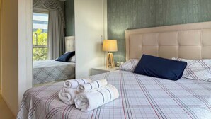A hotel room with a bed, a nightstand, a lamp, and a mirror. - LUXURY APARTMENT IN ASUNCIÓN, PARAGUAY: THE TOWER (Asunción)