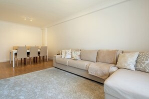A modern living room with a sofa, a dining table with chairs, and a carpet. - Roots of Gaia by Hommelier (Vila Nova de Gaia)