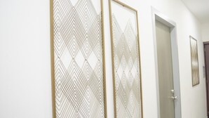A hallway with two wall-mounted decorative panels and a door. - Departamento Marina · Alberca · Balcón · Cerritos (Mazatlán)