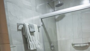 A modern bathroom with a toilet, sink, and glass-enclosed shower. - Departamento Marina · Alberca · Balcón · Cerritos (Mazatlán)
