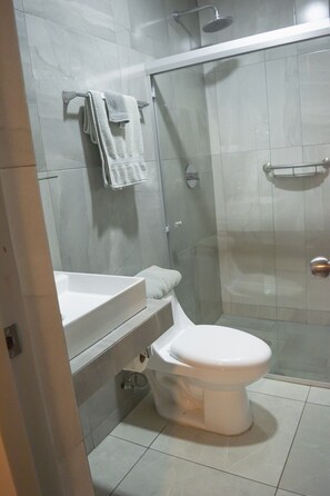 Ein modernes Badezimmer mit Toilette, Waschbecken und einer Duschkabine.