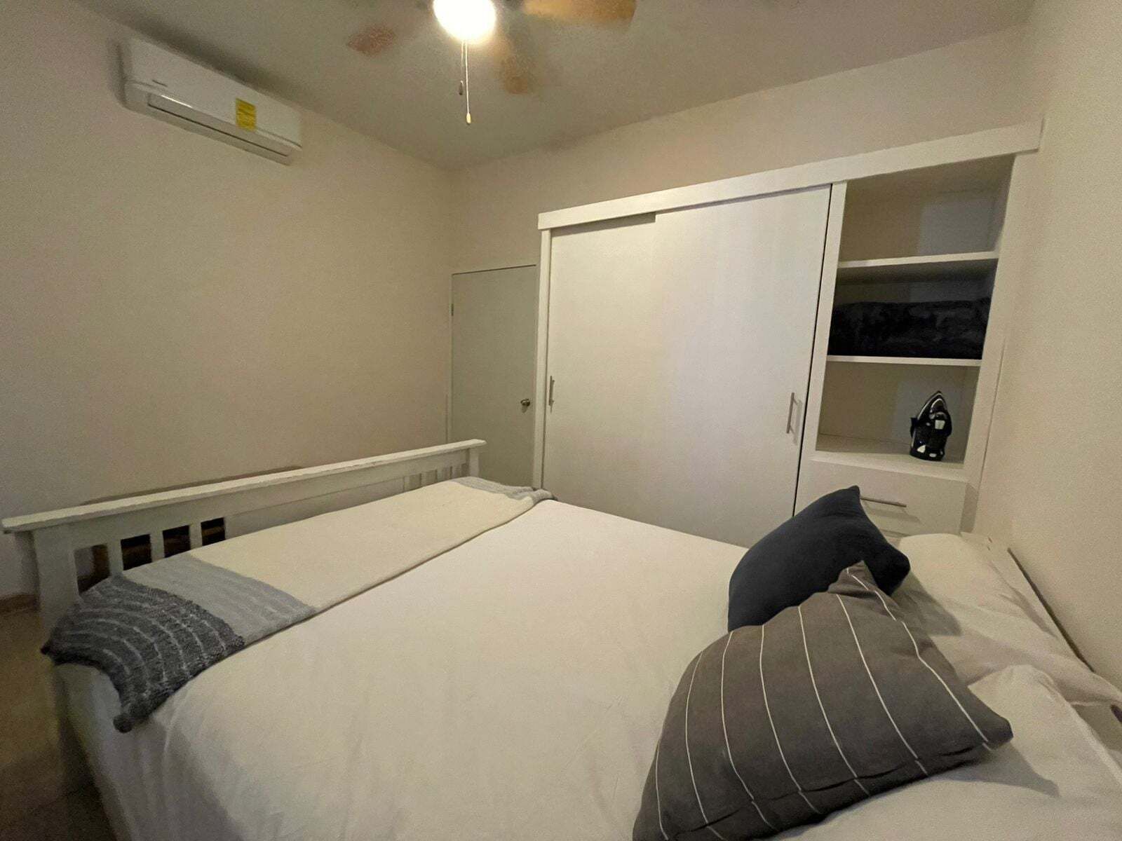 An interior view of a comfortable bedroom inside La Kasa #1, highlighting the spacious built-in wardrobe and clean layout designed for guest storage and convenience.
