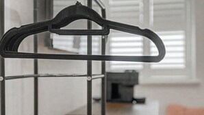 Ein schwarzer Kleiderbügel an einem Metallgestell.