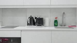Eine Küche mit Wasserkocher, Toaster und Geschirrspülmittel auf der Arbeitsfläche.