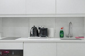 A kitchen with a kettle, toaster, and dish soap on the counter. - GuestReady - Chic City Studio in Vibrant Liverpool (Liverpool)