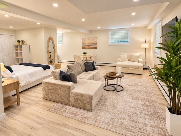 A modern living room with a sofa, a bed, and a dining area.