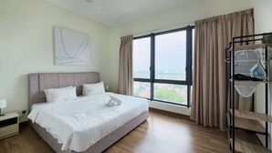 Ein modernes Hotelzimmer mit einem großen Bett, einem Nachttisch, einem Wandbild, einem Fenster mit Vorhängen und Blick auf die Stadt.
