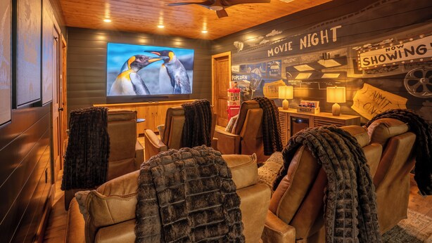 A cozy movie night room with a large screen, comfortable seating, and a popcorn sign. - Sauna, Cold Plunge, Hot Tub & Theater - Ellie Blue (Ellijay)