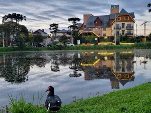 Ein Hotel mit Teich, in dem sich die Architektur spiegelt, umgeben von viel Grün.