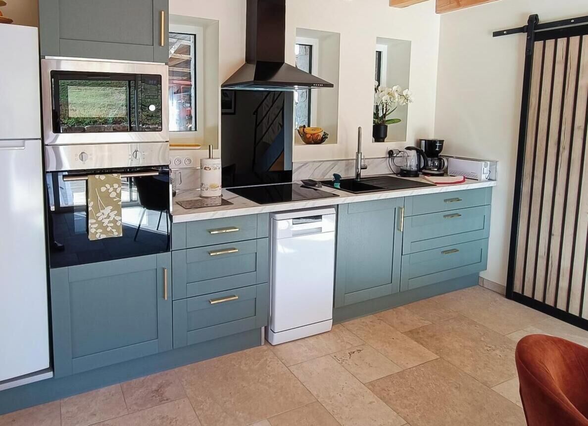 A kitchen with a dishwasher, oven, and a large window.