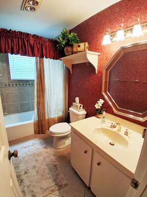 Ein Badezimmer mit Badewanne, Toilette, Waschbecken und Waschtisch.