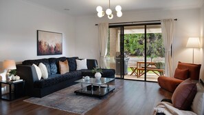 Ein Wohnzimmer mit einer Couch, einem Couchtisch und einem Gemälde an der Wand.