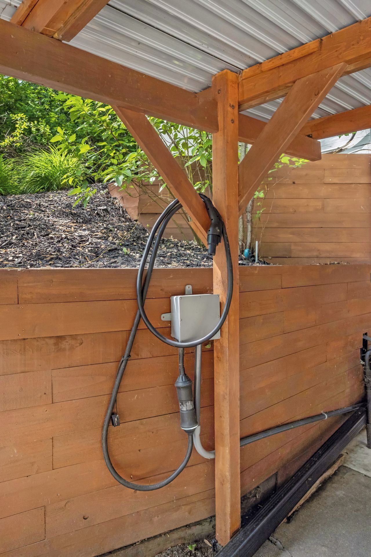 A wooden structure with a metal box and hoses.