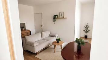 Un salon moderne avec un canapé, une petite table ronde et une table à manger.