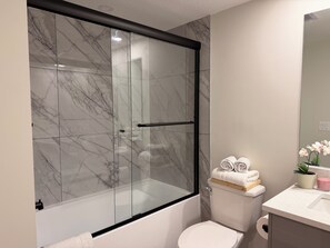 Ein Badezimmer mit Duschkabine, Toilette und Waschbecken.