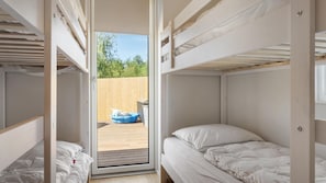 A bunk bed room with a sliding door leading to an outdoor area with a blue boat. - VillaVilla 981 - Hostrup Strand, Limfjorden (Spøttrup)