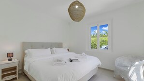 Une chambre à coucher avec un lit, une table de chevet, une lampe, une fenêtre et une chaise.