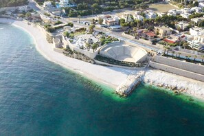 An aerial view of a coastal area with a large amphitheater, a beach, and residential buildings. - La Chicca Sul Mare Sea View, Bisceglie, Italy (Bisceglie)
