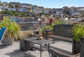 A rooftop terrace with a table, bench, and potted plants. - Harbour View at No.11, an exceptional coastal holiday home in Brixham (Brixham)