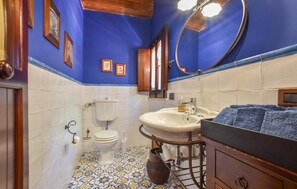 A bathroom with a toilet, sink, and mirror. - Nice home in Partinico (Partinico)