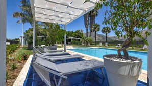 A poolside area with lounge chairs, a pergola, and a potted tree. - Nice home in Partinico (Partinico)