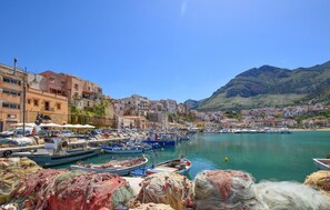 A coastal town with a marina filled with boats, buildings along the waterfront, and a mountainous backdrop. - Nice home in Partinico (Partinico)