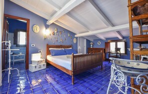 A bedroom with a wooden bed, a nightstand, a dresser, a mirror, and a decorative wall with various items. - Nice home in Partinico (Partinico)