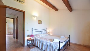 A bedroom with a bed, a nightstand with a lamp, a picture on the wall, and a door leading to another room. - Amazing home in Montecchio (Montecchio)
