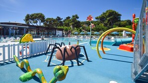 Een speelruimte voor kinderen met een zwembad, glijbanen en kleurrijke speeltoestellen.