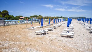 A beach with rows of white sun loungers and blue umbrellas. - Pet friendly home in Torino di Sangro with WiFi (Torino di Sangro)