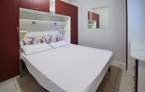 A bedroom with a bed, a wardrobe, a mirror, and a small bathroom area. - 2 bedroom beautiful home in Torino di Sangro (Torino di Sangro)