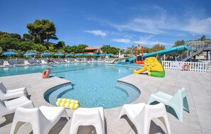 A swimming pool with lounge chairs, a slide, and a lifeguard stand. - 2 bedroom beautiful home in Torino di Sangro (Torino di Sangro)