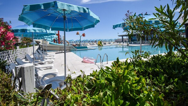 A pool area with lounge chairs, umbrellas, and a clear view of the ocean. - 2 bedroom beautiful home in Torino di Sangro (Torino di Sangro)
