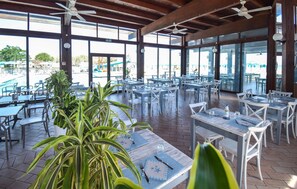 A covered outdoor dining area with tables and chairs, large windows, and ceiling fans. - Lovely home in Torino di Sangro (Torino di Sangro)