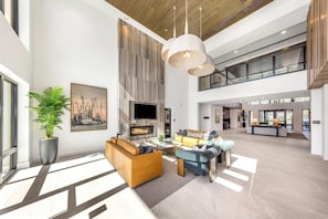 A spacious living area with a fireplace, sofas, and a large plant. - Landing Beautiful 1BD in Downtown Largo (Clearwater)