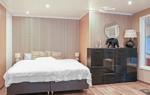 Ein Schlafzimmer mit einem Bett, einem Schminktisch, einem Spiegel und einem Fenster.