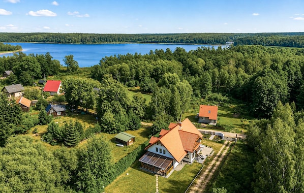 A residential area with houses, a lake, and dense forest.