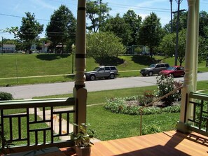 Eine Veranda mit Blick auf eine Straße, einen Garten und ein Wohngebiet.