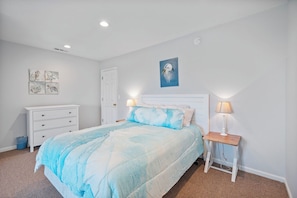 A bedroom with a bed, bedside tables, a dresser, and wall art. - Gorgeous Bay Views - No Egrets by Seaside Vacations! (Chincoteague)