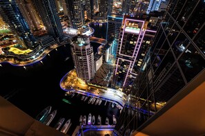 Ein Hochhaus mit einem Hubschraublandeplatz, Blick auf das Wasser und einem Yachthafen mit Booten.