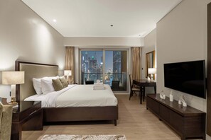 A modern hotel room with a large bed, a desk, a television, and a city view. - Chic Studio JW Marriott Dubai Marina (Dubai)