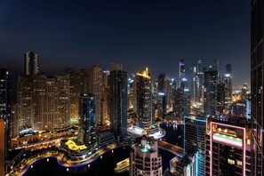 A nighttime cityscape with high-rise buildings, a river, and a bridge. - Chic Studio JW Marriott Dubai Marina (Dubai)
