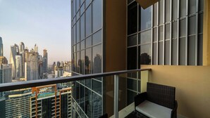Uma varanda com vista para a cidade, uma cadeira e uma mesa.
